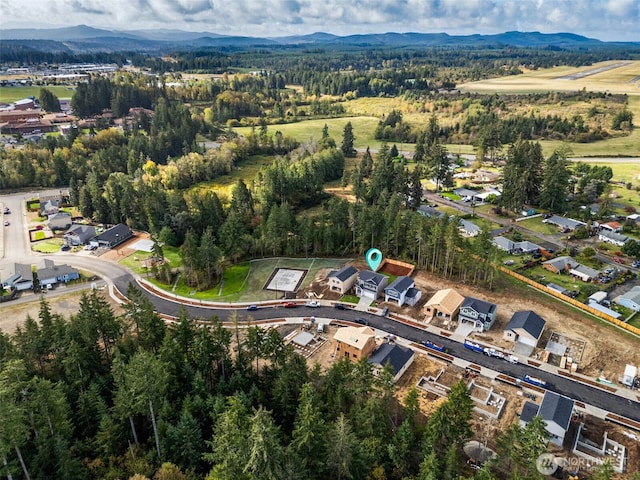 birds eye view of property with a mountain view and a forest view