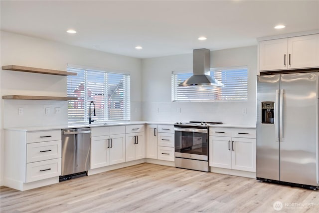 kitchen featuring light countertops, stainless steel appliances, tasteful backsplash, light wood-type flooring, and ventilation hood