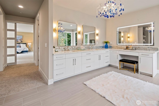 full bathroom with a notable chandelier, backsplash, and a sink