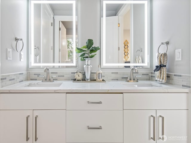 full bathroom with a sink, decorative backsplash, and double vanity