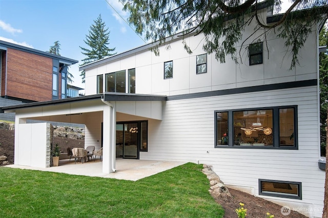 back of house with a yard and a patio