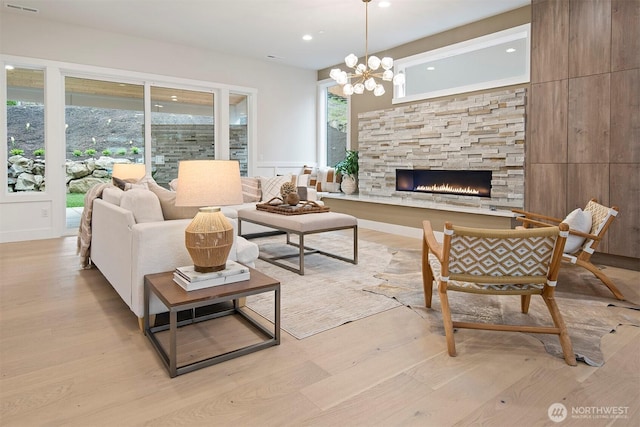 living area featuring recessed lighting, an inviting chandelier, wood finished floors, and a fireplace