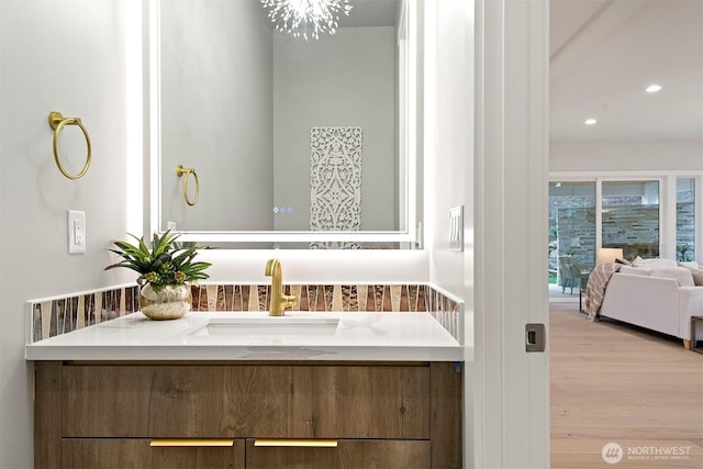 bathroom with vanity, recessed lighting, wood finished floors, and a chandelier