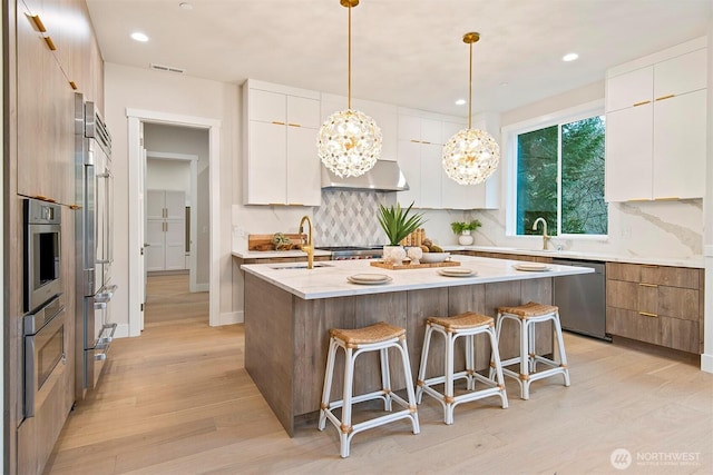 kitchen with a breakfast bar area, stainless steel appliances, and modern cabinets