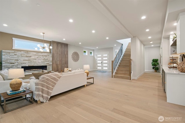 living area featuring stairway, recessed lighting, a fireplace, and light wood-style flooring