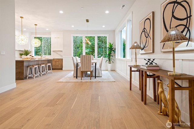 dining room with recessed lighting, light wood-style floors, a healthy amount of sunlight, and a chandelier