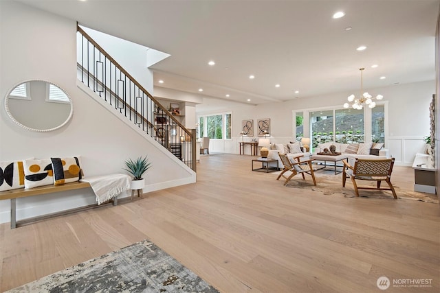 interior space featuring an inviting chandelier, recessed lighting, stairs, a decorative wall, and light wood-type flooring