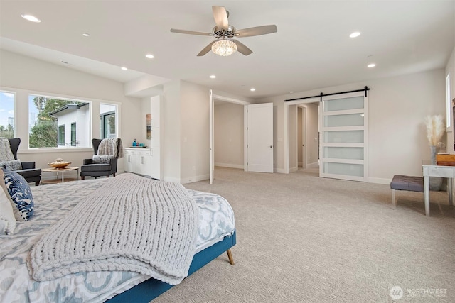 bedroom featuring light colored carpet, a barn door, recessed lighting, and baseboards