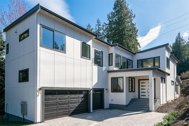 contemporary house with decorative driveway and a garage