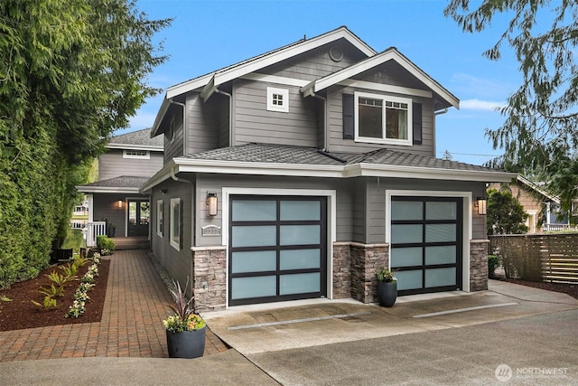 view of front of home featuring fence, covered porch, a garage, stone siding, and driveway