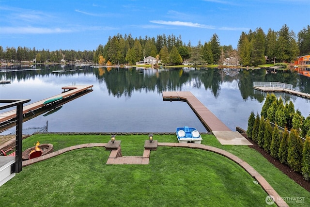 dock area with a lawn and a water view