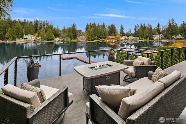 exterior space featuring an outdoor living space with a fire pit and a water view