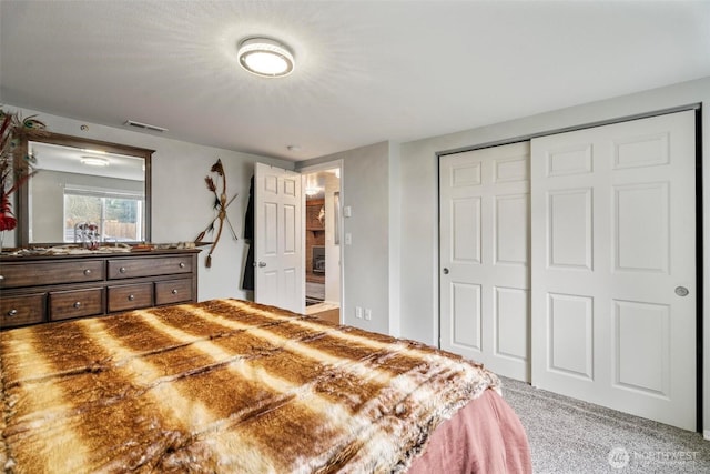 carpeted bedroom featuring a closet and visible vents