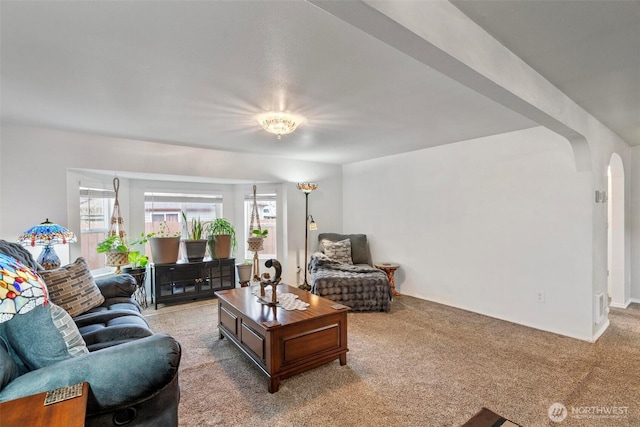 living room with arched walkways and carpet floors