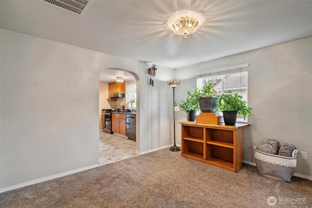 interior space with visible vents, baseboards, light carpet, arched walkways, and a sink