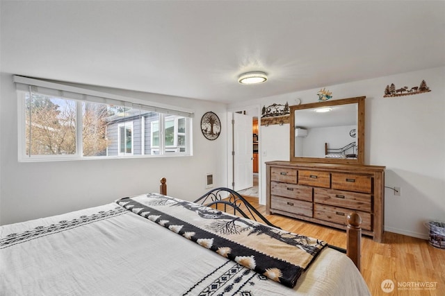 bedroom with visible vents, light wood-style floors, and baseboards