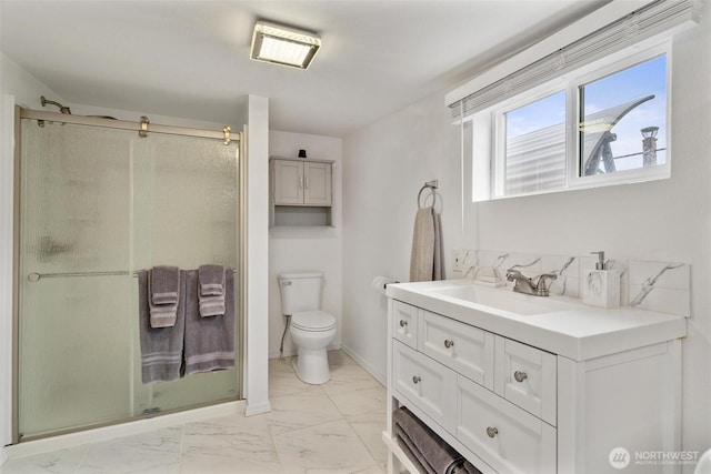 bathroom with vanity, marble finish floor, a shower stall, and toilet