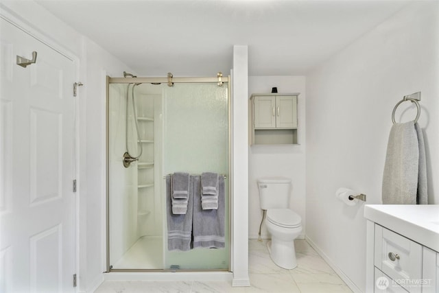 bathroom with toilet, marble finish floor, a stall shower, baseboards, and vanity