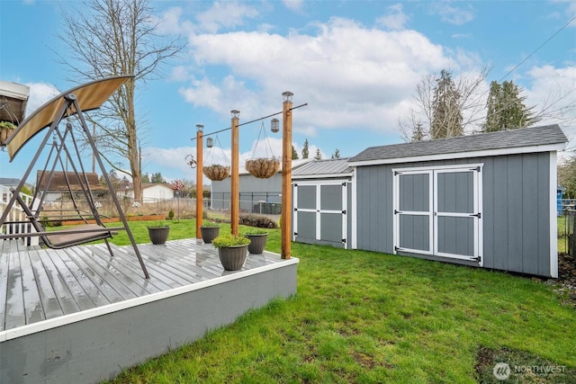 view of yard featuring a wooden deck, an outbuilding, a fenced backyard, and a shed