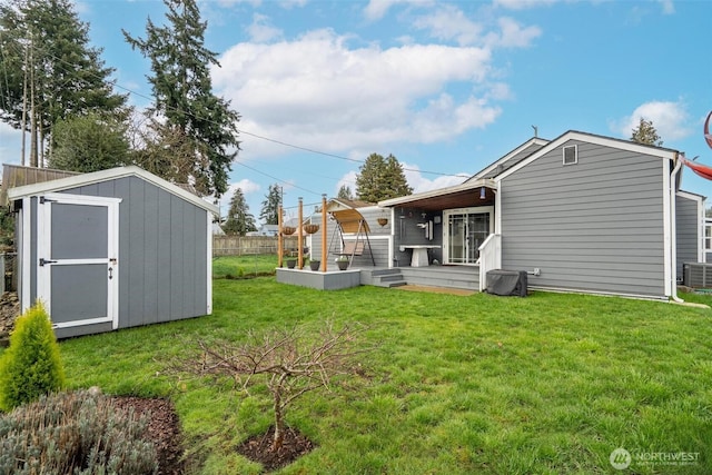 view of yard with an outbuilding, a storage shed, and fence