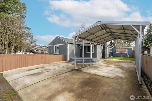 view of parking featuring a carport, driveway, and fence