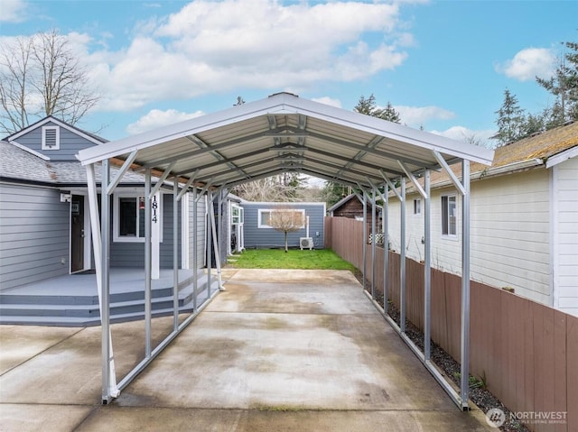 view of vehicle parking featuring a carport, fence, and driveway