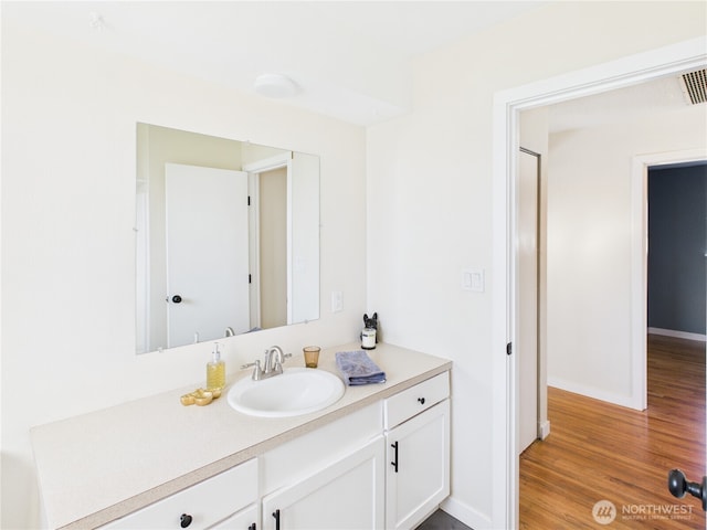 bathroom with vanity, baseboards, and wood finished floors