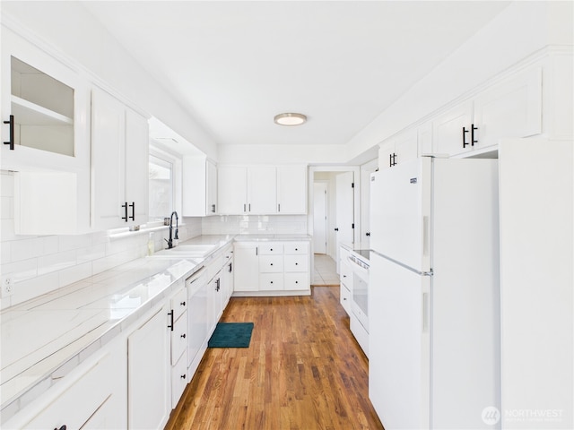 kitchen with a sink, decorative backsplash, white appliances, and white cabinets