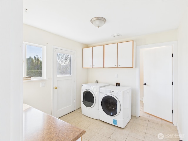 laundry area with light tile patterned floors, visible vents, cabinet space, and independent washer and dryer