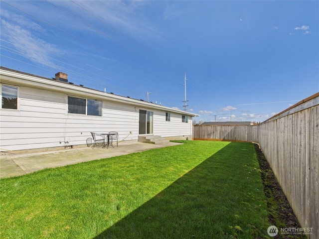 rear view of property with a patio, a fenced backyard, a chimney, entry steps, and a lawn