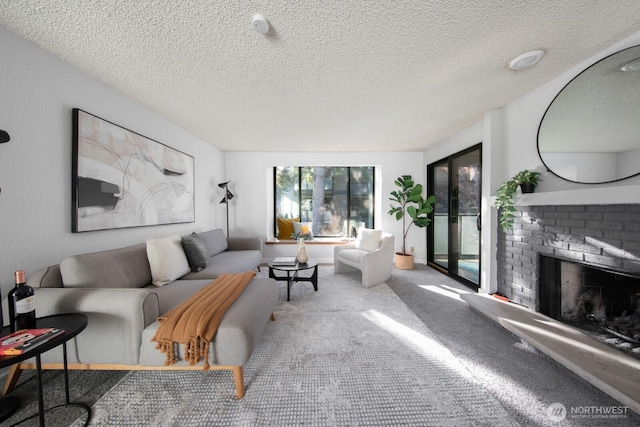 living area featuring a brick fireplace, a textured ceiling, and carpet floors