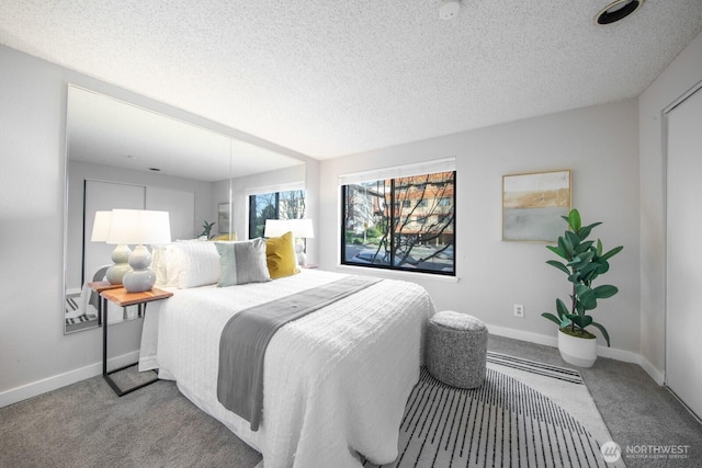 bedroom featuring baseboards, carpet floors, and a textured ceiling