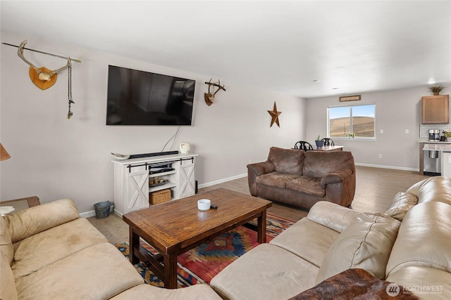 living area with baseboards and wood finished floors