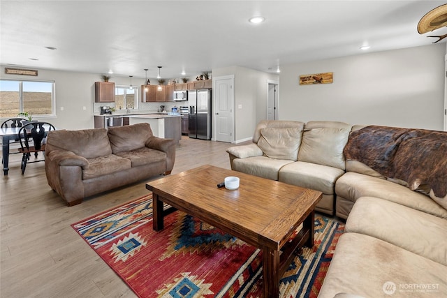 living area featuring recessed lighting, light wood-type flooring, and baseboards