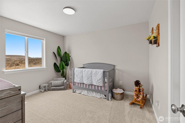 bedroom with carpet flooring, baseboards, and a nursery area