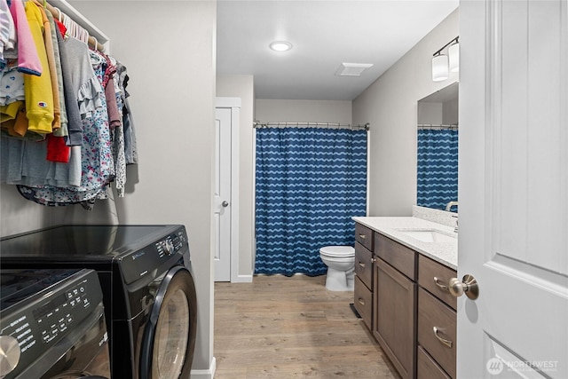 full bathroom with separate washer and dryer, wood finished floors, vanity, and toilet