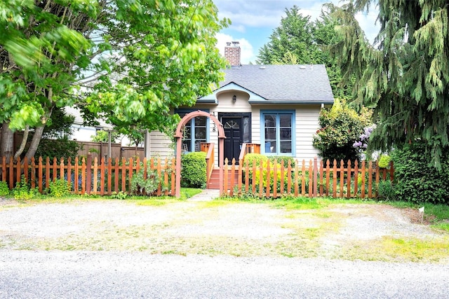 10538 Evanston Ave N, Seattle, WA 98133 - view of front of house featuring a chimney, a fenced front yard, and a shingled roof