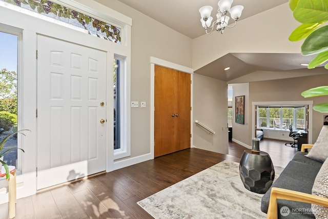 entrance foyer featuring vaulted ceiling, wood finished floors, baseboards, and a chandelier