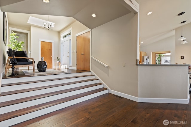 foyer with visible vents, lofted ceiling, recessed lighting, a notable chandelier, and wood-type flooring