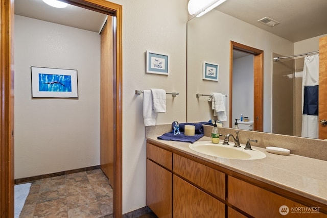 bathroom with visible vents, vanity, a shower with shower curtain, and baseboards