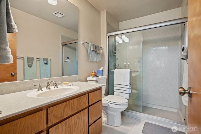full bathroom with vanity, toilet, visible vents, and a stall shower