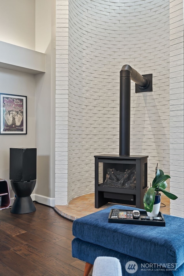 room details with a wood stove, baseboards, and wood finished floors