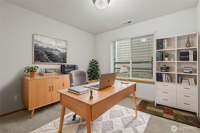 office with visible vents, baseboards, and light colored carpet