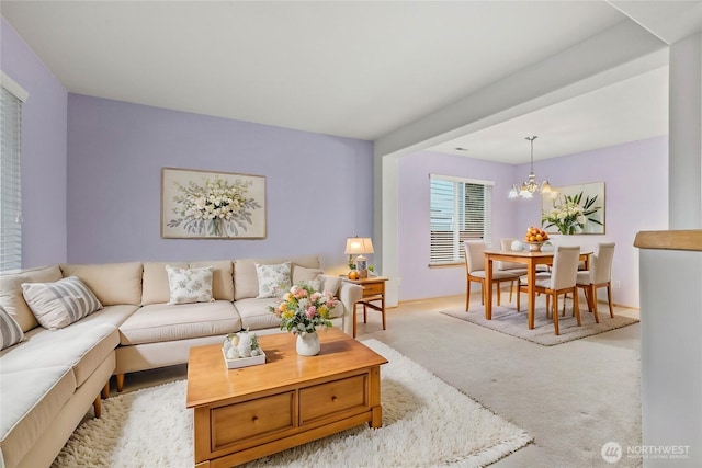 living area with a chandelier and light carpet