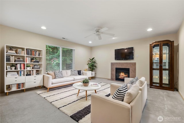 living area with ceiling fan, recessed lighting, carpet floors, and a tile fireplace