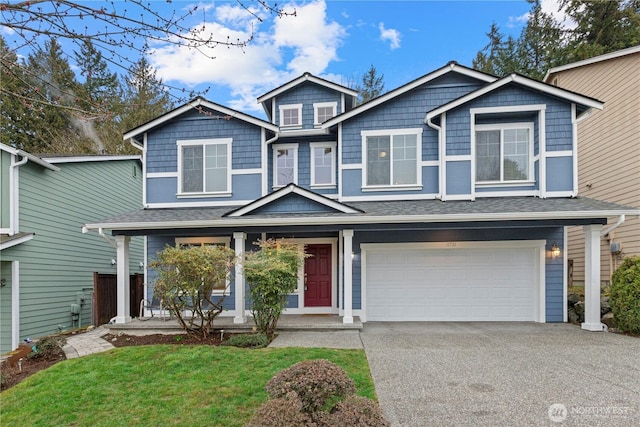 view of front of house featuring a porch, a front yard, a garage, and driveway