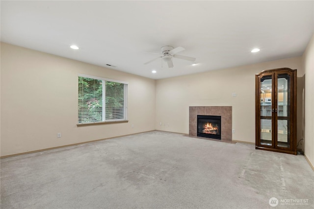 unfurnished living room with a ceiling fan, baseboards, carpet floors, recessed lighting, and a tile fireplace