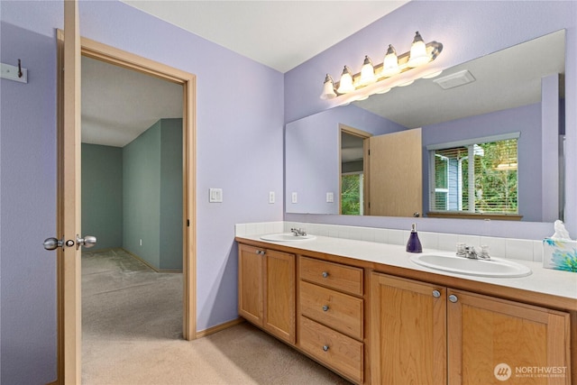 bathroom with double vanity, baseboards, and a sink