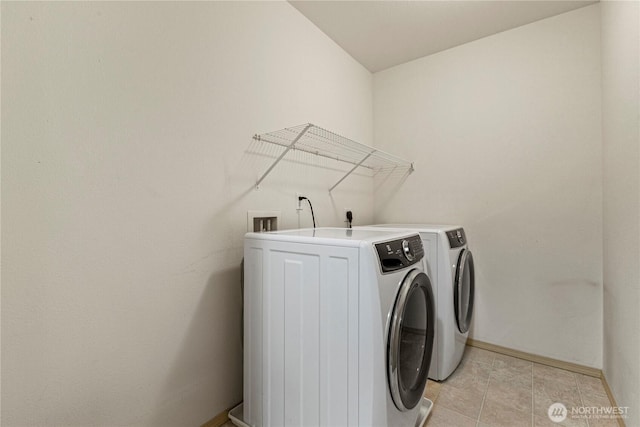 laundry room featuring laundry area, light tile patterned floors, baseboards, and washer and clothes dryer