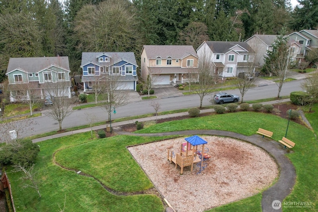 view of yard with a residential view, driveway, and an attached garage